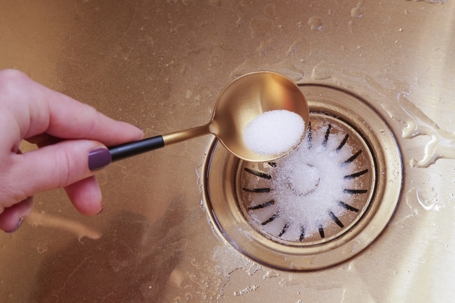 Cleaning kitchen sink with bakIng soda